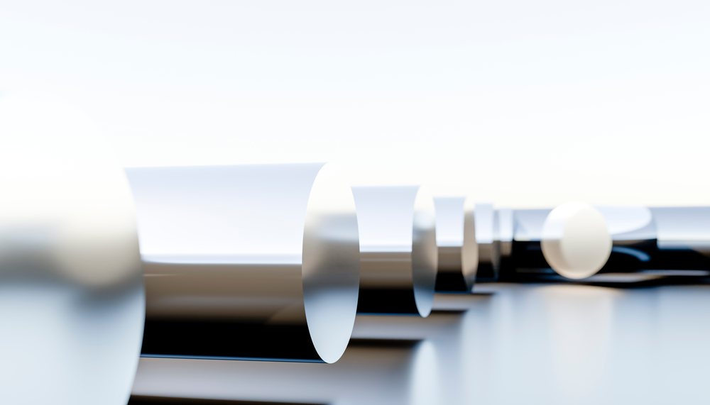 Abstract composition of black and white metallic cylinder sections and spheres arranged in a linear sequence creating a minimalist and modern design.