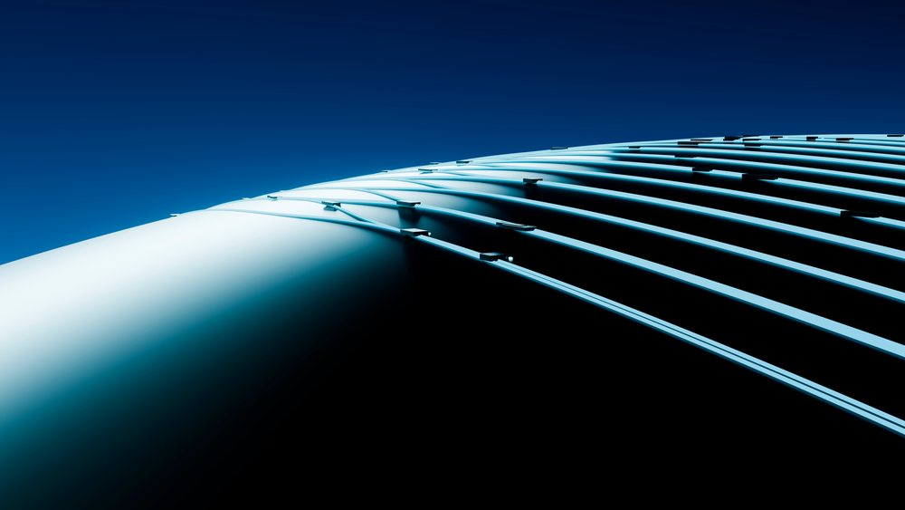 Curved metal architectural structure with parallel lines and shadows set against a deep blue sky.