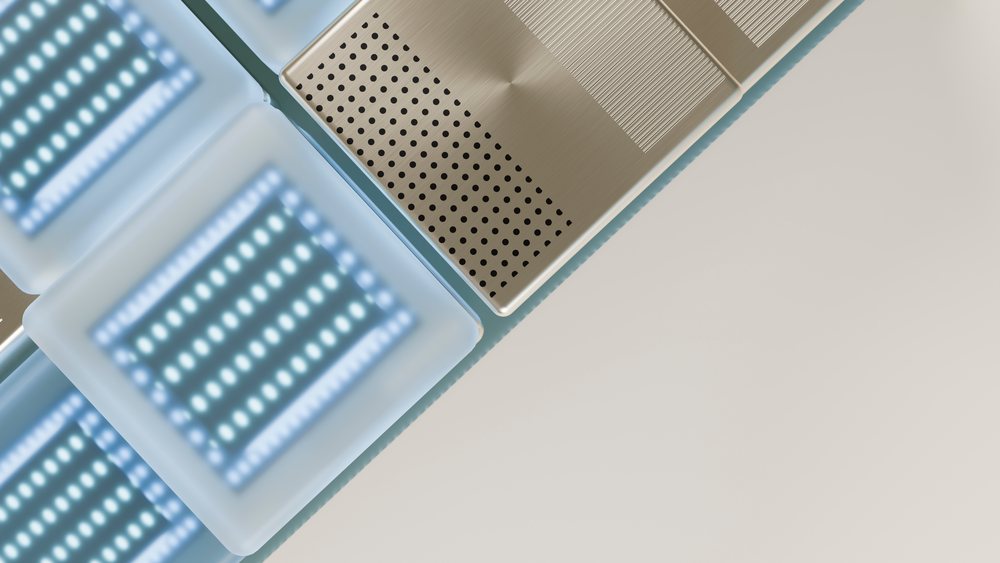 LED light panels with blue and white illumination and perforated metal panels placed closely together on a white surface in a studio environment.