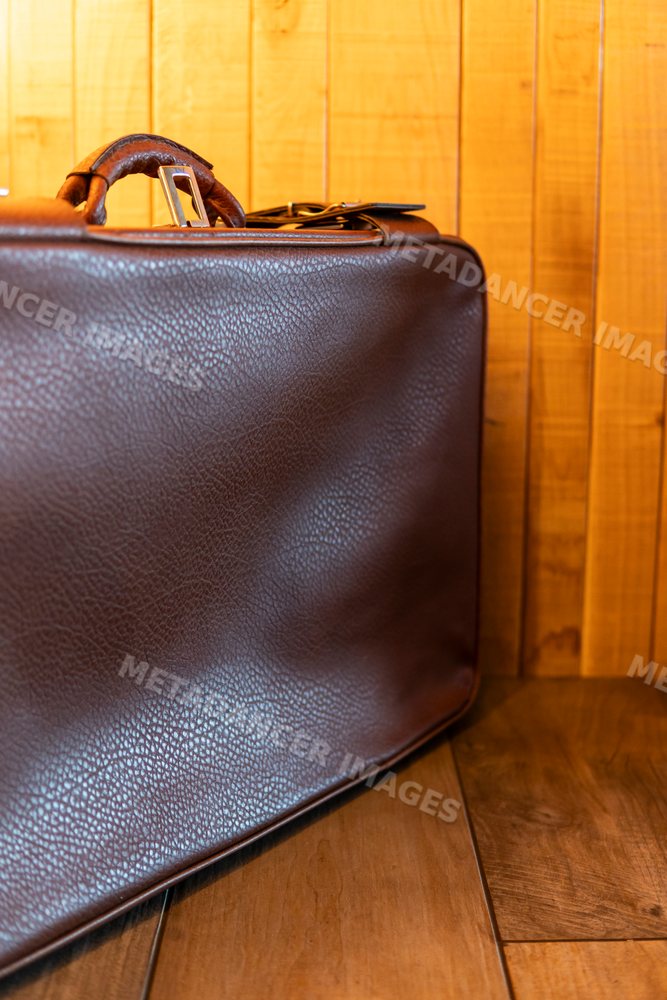 Close-up of a brown leather bag against a wooden wall in Verdun