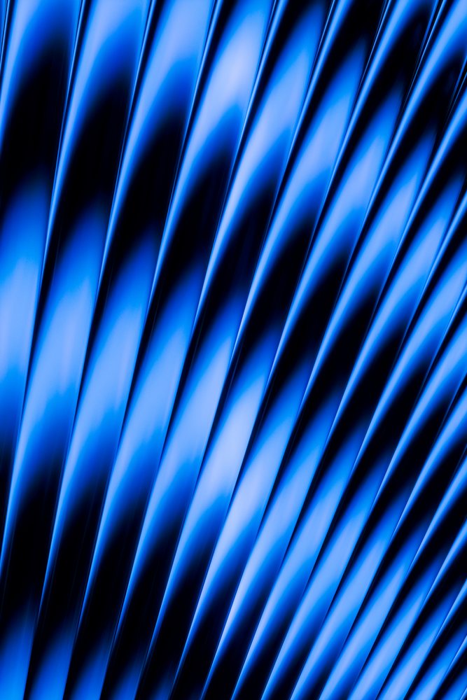 Abstract blue diagonal wave pattern with gradient lighting creates a textured surface background.
