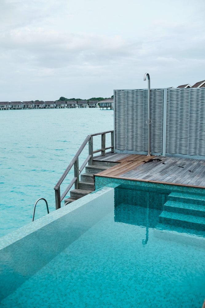 An infinity pool with outdoor shower at a tropical resort