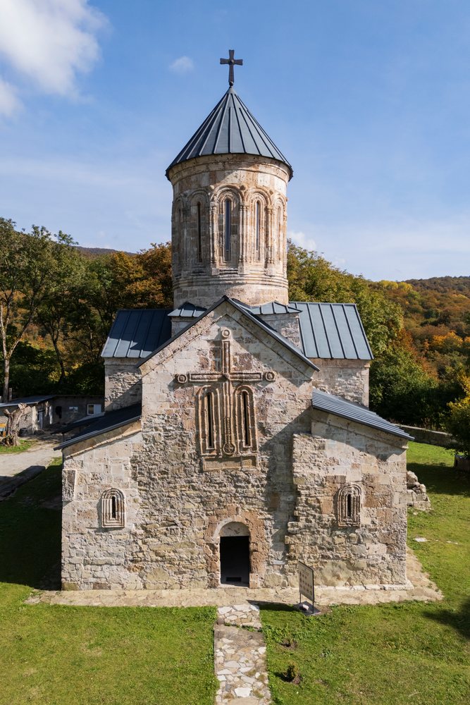 Pudzinari Monastery, a 13th-century medieval Christian stone church with a cross atop its tower, Dusheti Municipality, Georgia.