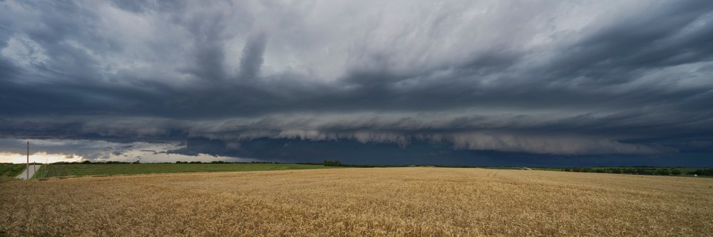 Supercell storm with layered dark clouds approaches a wheat field, in the Great Plains, Weather, Environmental Issues, Storm Chasing, Leonardville, Kansas, USA.