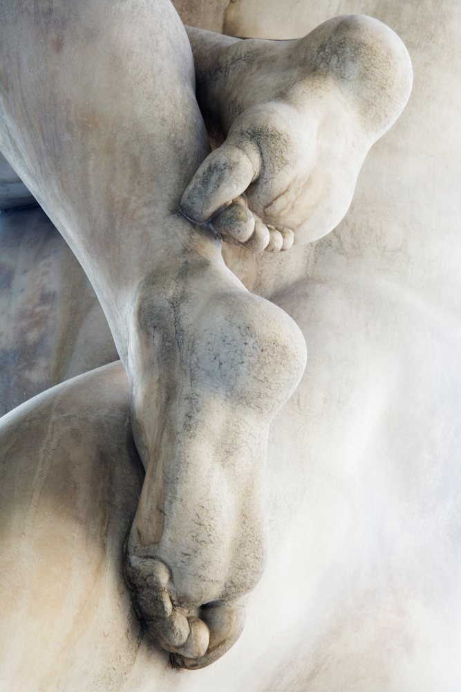 Close-up image showing detailed feet carving on a marble sculpture, Florence, Italy.