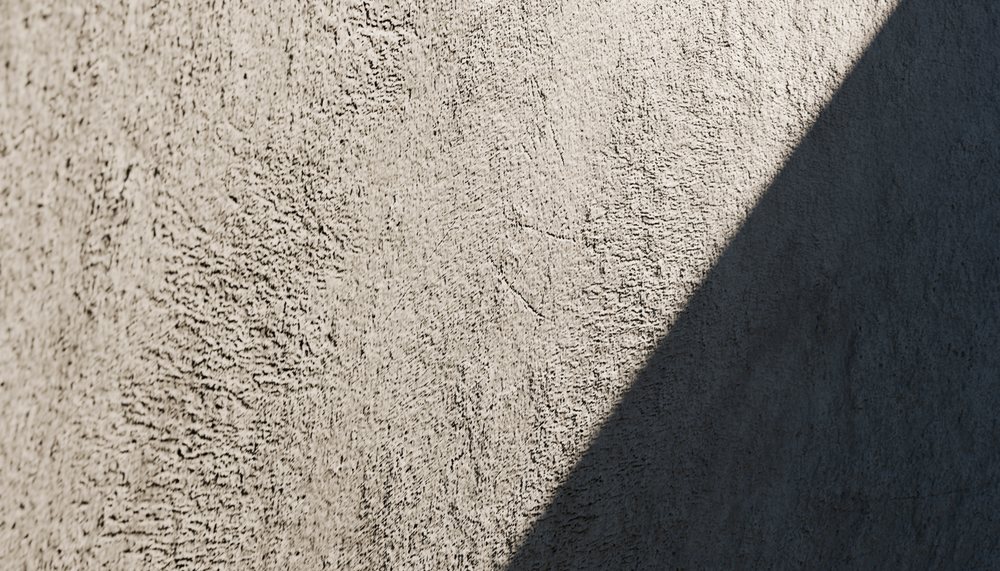Diagonal shadow on a textured rough concrete wall surface