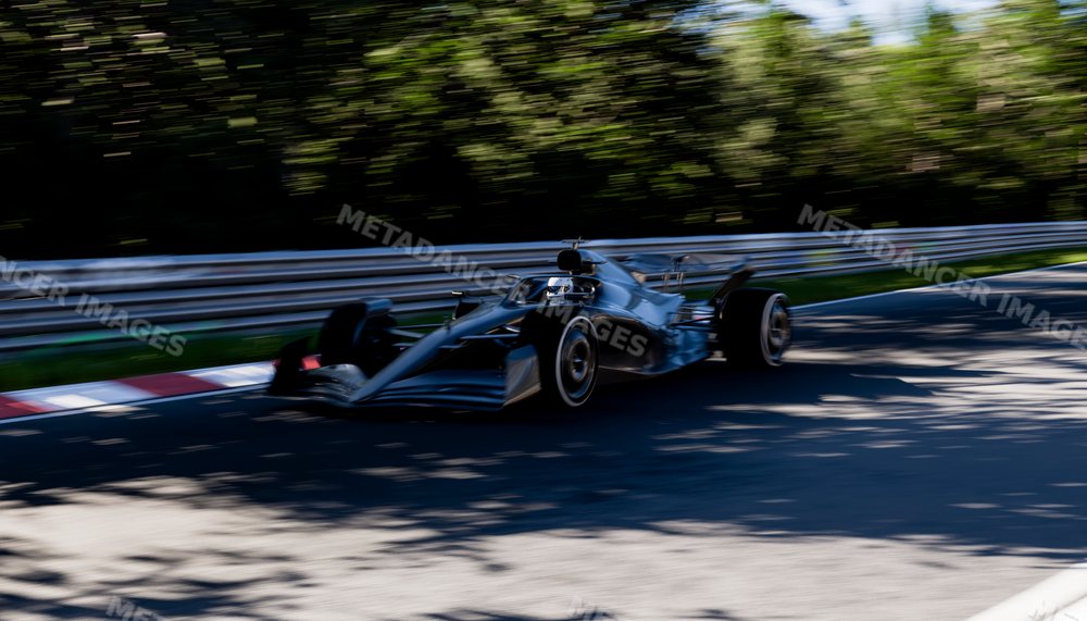 Black racecar speeding around a corner on a race track