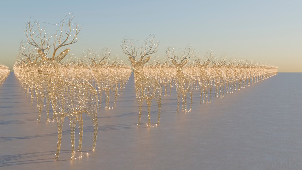 Wireframe reindeer sculptures with glowing lights arranged in multiple rows on a flat surface at evening time.