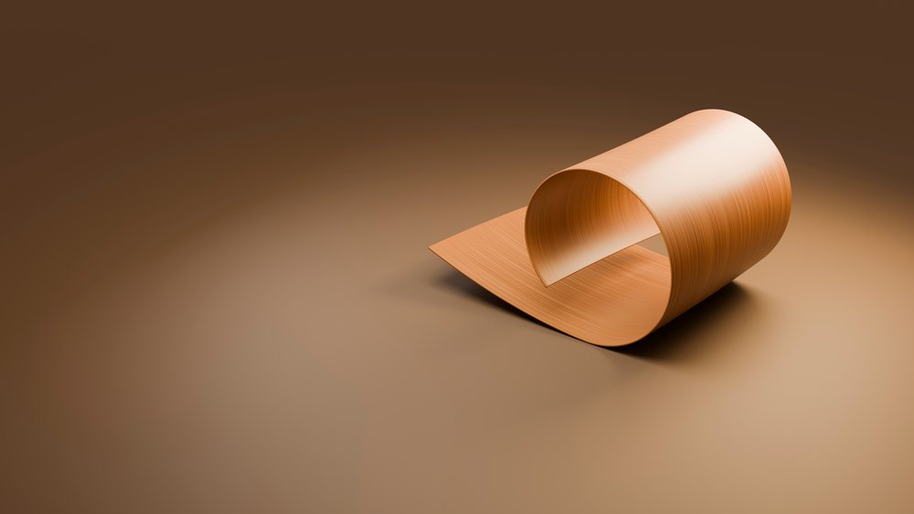 Smooth curved wooden sheet forming a loop on a brown surface in a minimalist setting.