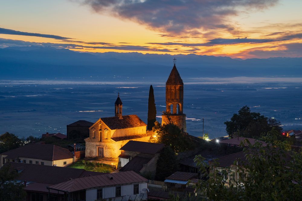St George's Church illuminated on a hilltop at Dawn overlooking the valley and mountains, Skylines, Sighnaghi, Georgia.