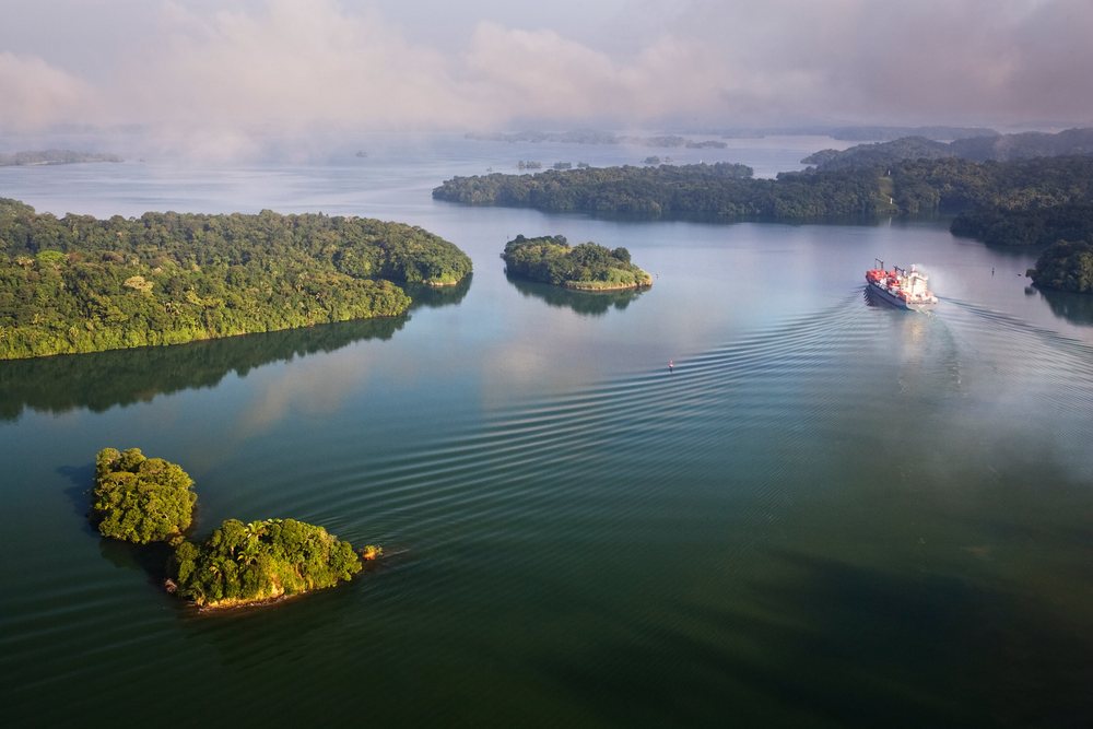 Container ship navigating Panama Canal waterway.