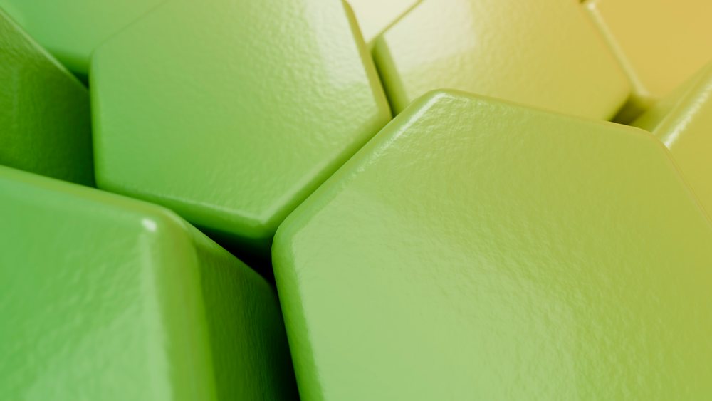 Close-up of green hexagonal shapes clustered with rounded edges and a shiny, smooth textured surface in a modern design.