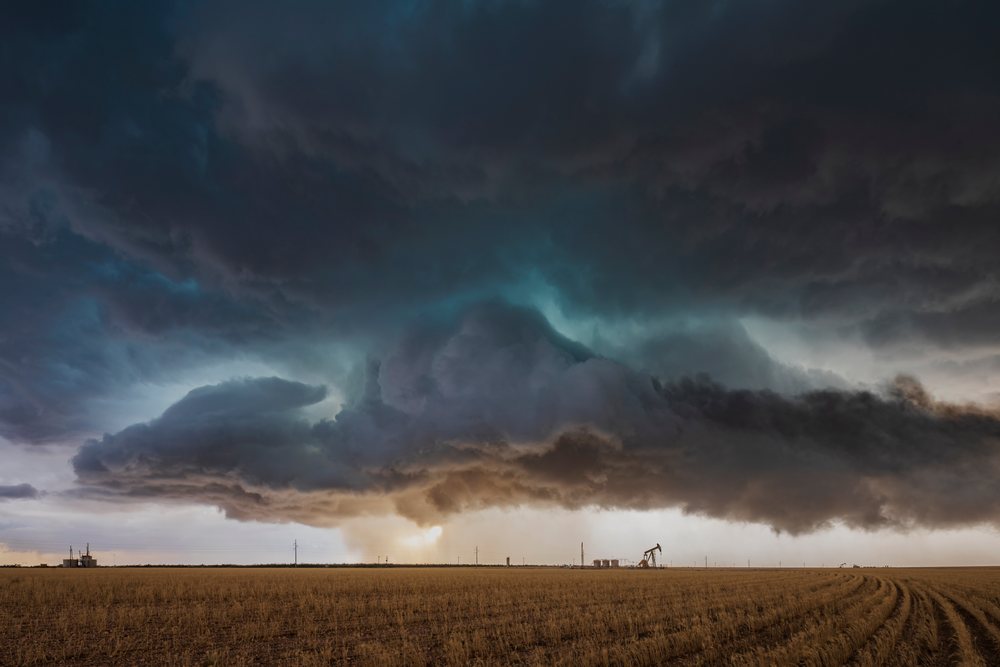 Severe-Warned Supercell storm develops over a flat field with oil pumpjacks, Garden City, Texas, USA.