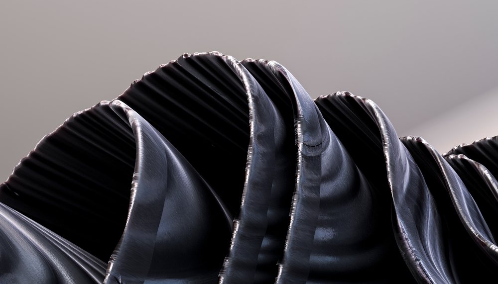 Close-up of black pleated fabric showing curved folds and silky texture in soft light.