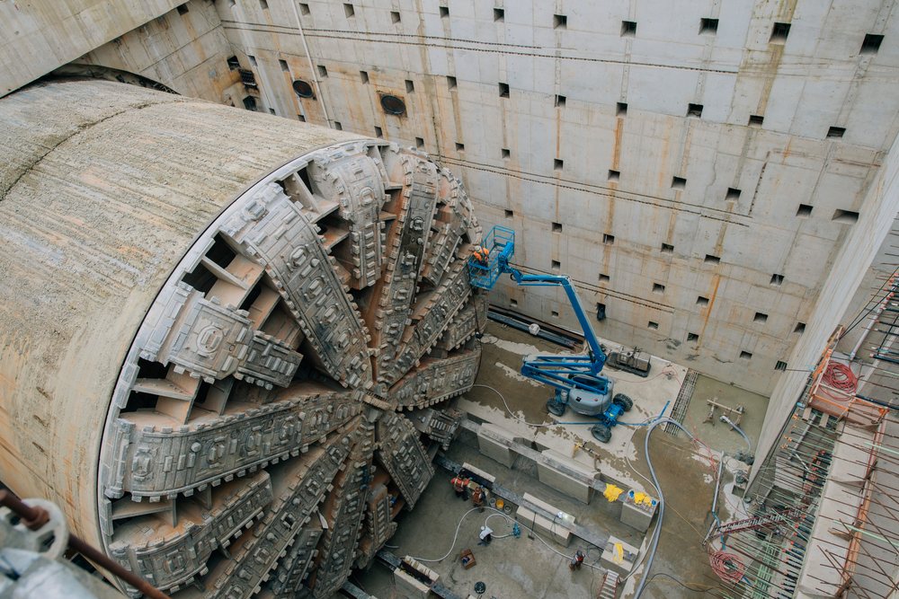 A tunnel boring machine is positioned inside a large concrete construction site with workers performing maintenance, a tunnel boring machine, drilling, USA.