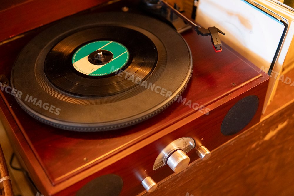 A vintage wooden turntable playing vinyl records with retro music
