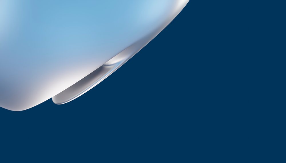 Closeup of a white ceramic cup handle against a dark blue background.