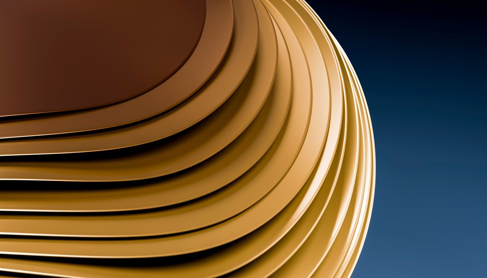 Stack of glossy brown ceramic plates with rounded edges arranged closely against a dark background.
