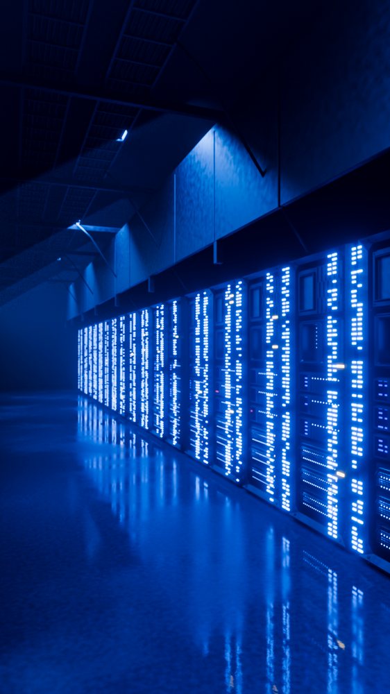 Blue lights illuminate server racks reflecting on the floor in a modern indoor data center room.