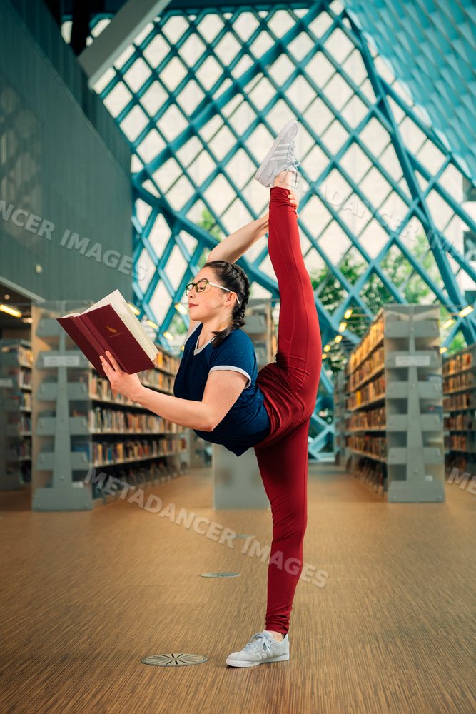A woman stretches her leg while reading a book