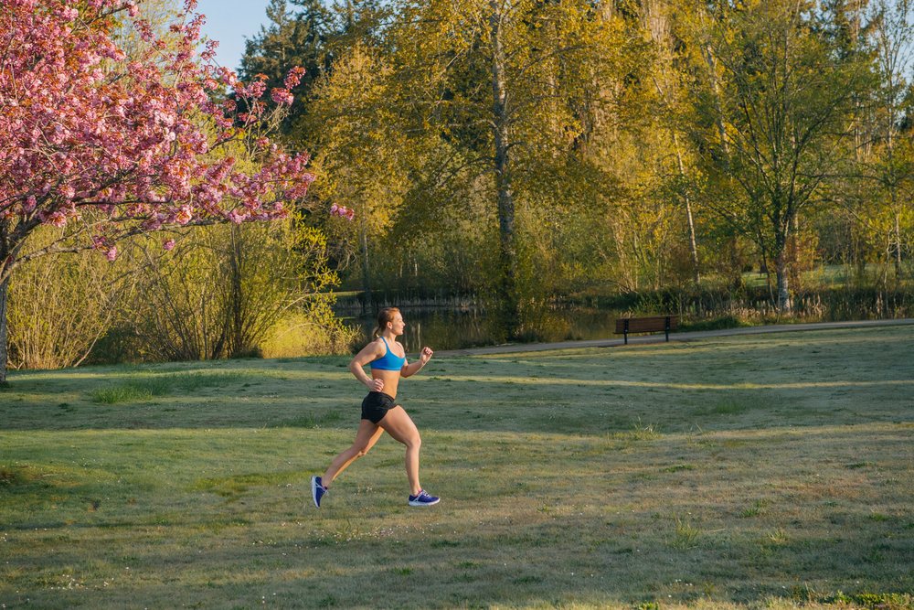 Woman jogging on a path in a park on Bainbridge Island in the morning, Wa, USA.