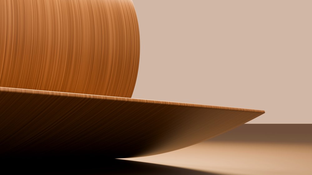 Smooth wooden plate and round wooden bowl on a brown surface in a minimalist setting.