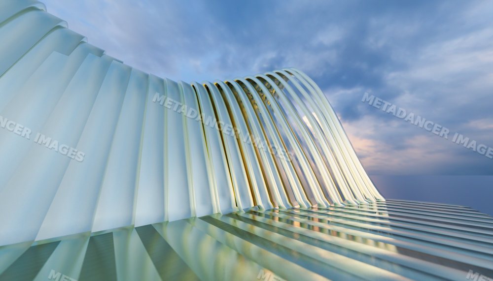 Curved metal architectural structure reflecting sunset light