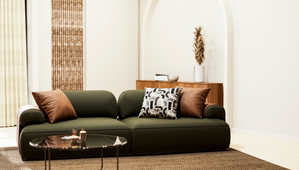Green modern sofa with brown and patterned pillows in a minimalist living room with a round glass table and wooden cabinet.