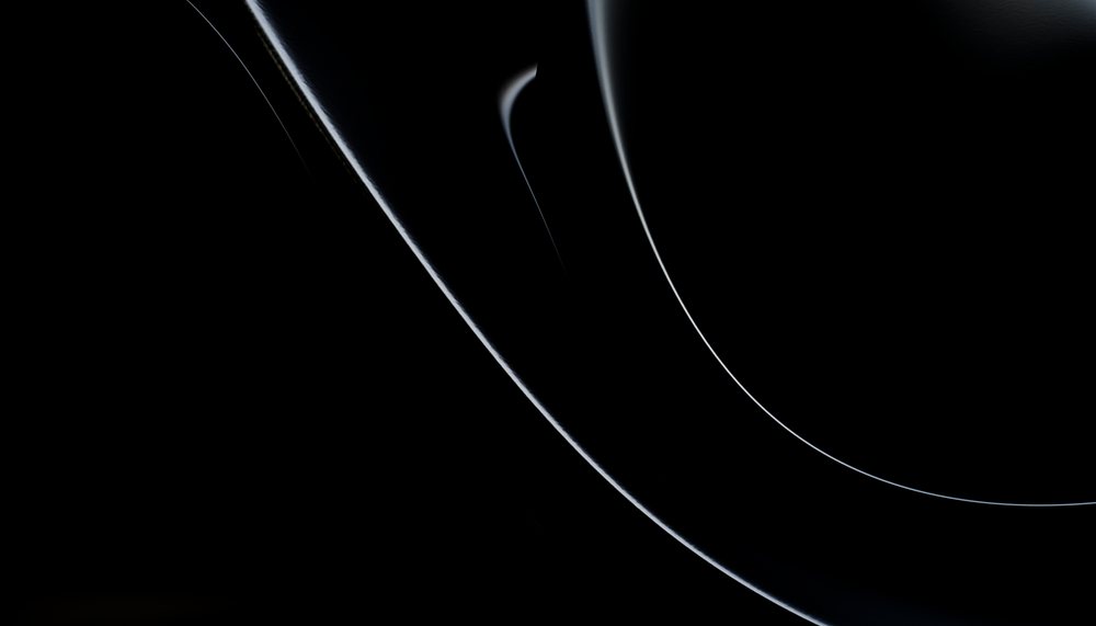 Close-up of black ceramic plates stacked and arranged in a sleek, minimalist style on a dark background.
