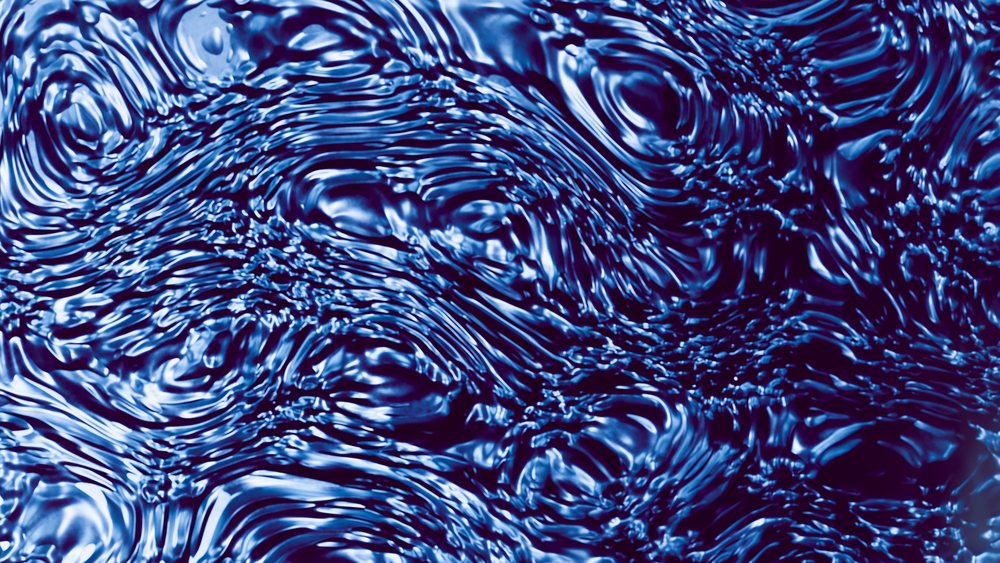 Water surface with reflective ripples and waves creating an abstract blue liquid texture.