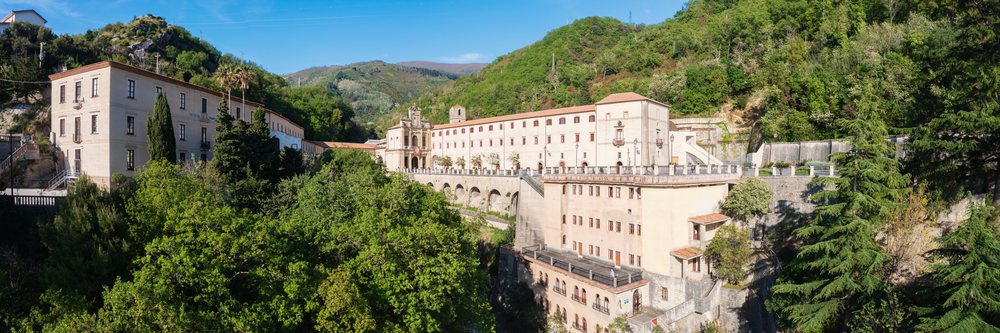 Santuario di San Francesco di Paola church sits on a green hillside, Italy beneath a sunny blue sky, Basilicata.