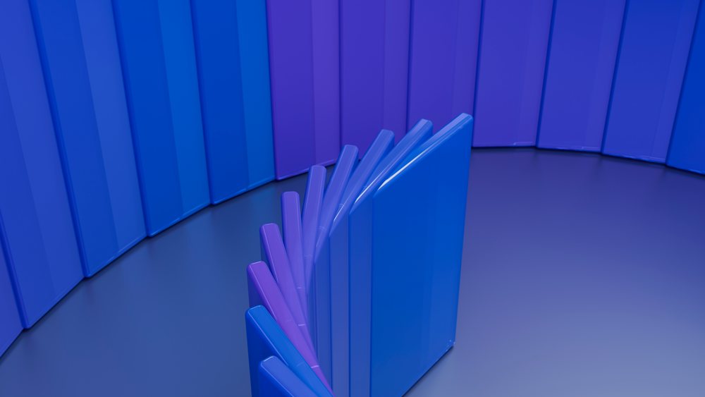 Blue and purple domino tiles arranged in a curved line, with some falling and creating a chain reaction on a smooth surface.