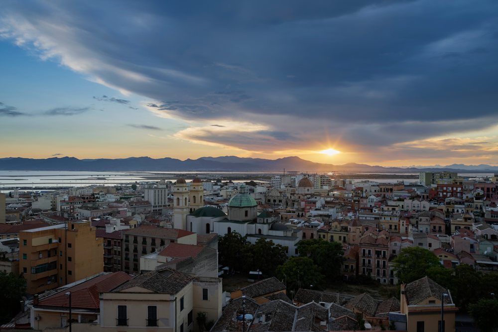 Sunset over Cagliari's cityscape and distant mountains with clouds, Travel Photography, Sardinia, Italy.