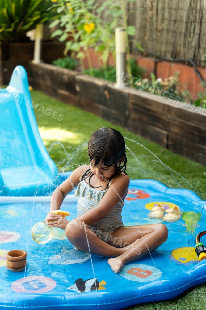 A young white girl plays with water