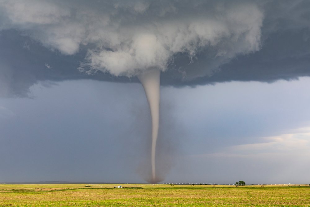 Tornado funnel descending from storm clouds over an open field in Tornado Alley, Dickens, Nebraska, USA.