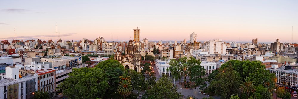Sunset cityscape featuring an urban park and historic church, Argentina.