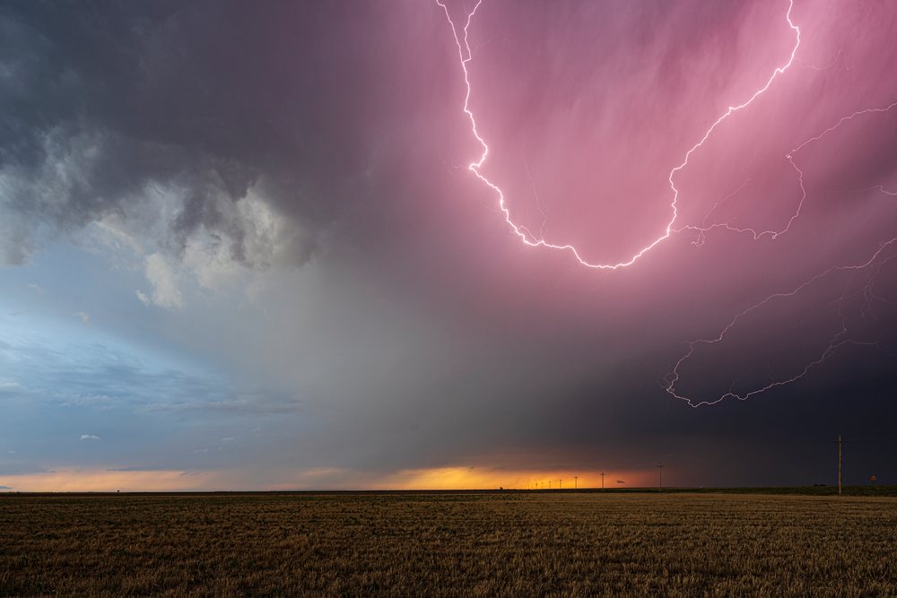 Lightning bolts amid dramatic Storm clouds over a rural open field at sunset, Storm Chasing, Weather, Environment, Ulysses, Kansas, USA.