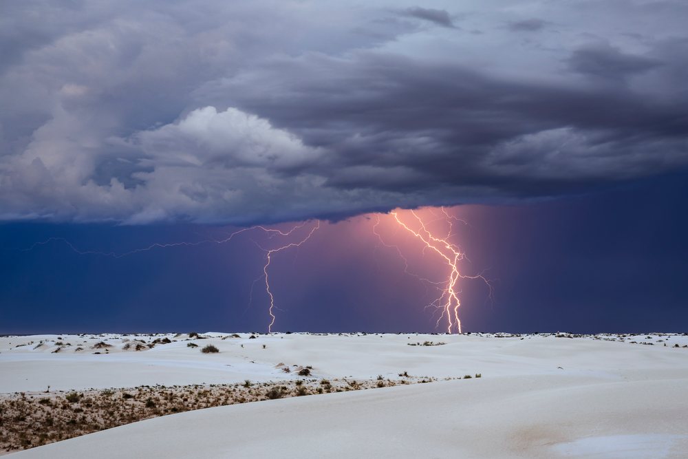 Lightning strikes over white sand dunes under dark storm clouds at white Sands National Park, Landscape, Wildlife, Alamogordo, New Mexico, USA.