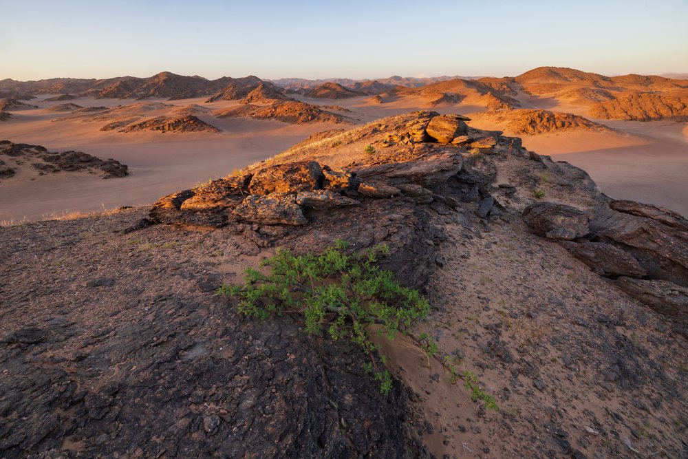 Rocky hills and sand dunes of Hoanib River Valley desert landscape, Kunene Region, Namibia.