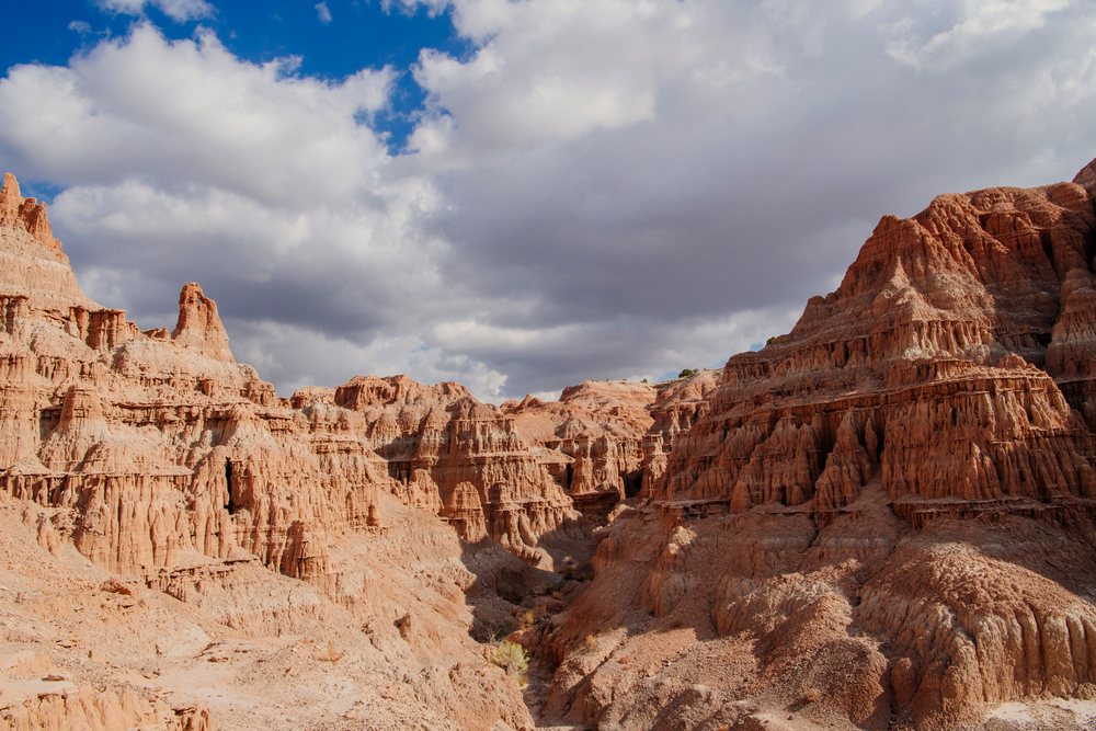 Eroded sandstone rock formations and cliffs under a cloudy sky at Cathedral Gorge State Park in Nevada desert, USA.
