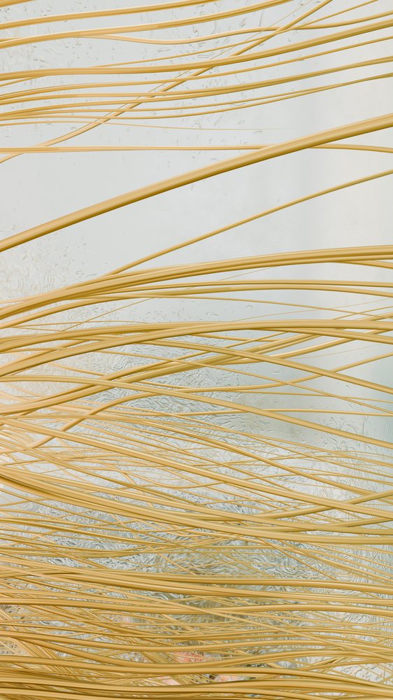 Yellow uncooked pasta strands tangled together forming a textured food background.