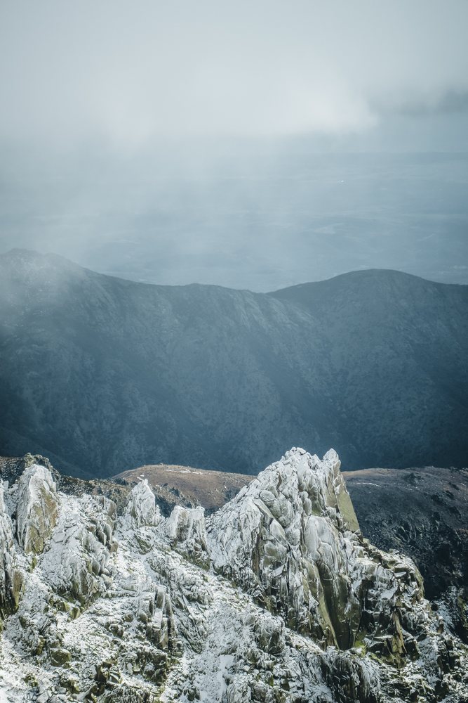 Snow-covered rocky mountain peaks with fog in the Spain mountain landscape, mountaineering, climbing, landscape.