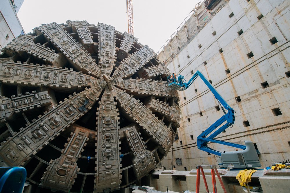 A large tunnel boring machine is set up inside a construction site in the USA for underground tunnel drilling.