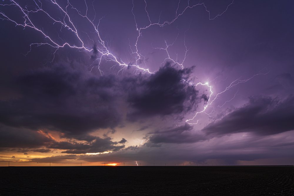 Lightning flashes across a stormy sky at sunset over plains, Colorado, Storm Chasing, Weather, Environmental issues, Sheridan Lake, Colorao, USA.