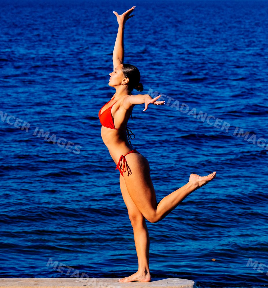Woman balancing on one leg near lake in washington, USA