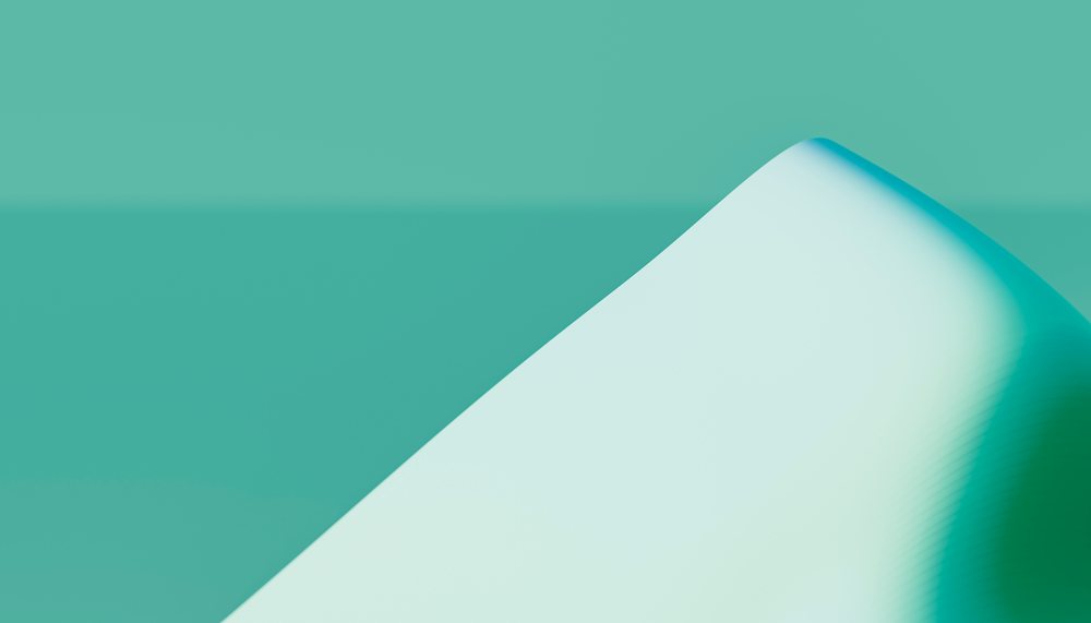 Close-up view of a smooth, curved white architectural surface with soft shadows against a teal background.