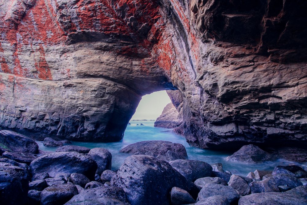 Devils Punch bowl natural rock arch formed by wave erosion with ocean visible through the opening on the Oregon coast, USA.