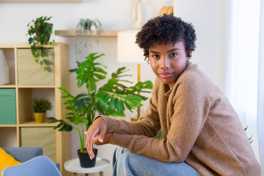 Young woman seated indoors in a cozy home.