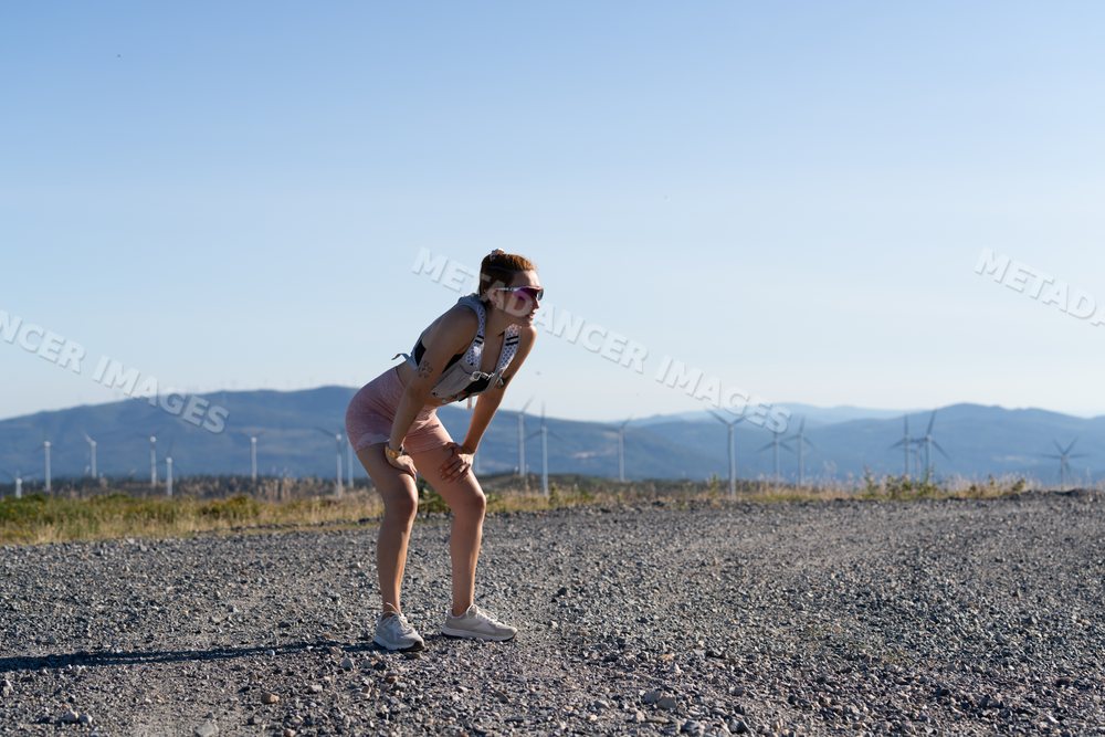 White Woman taking a break after running on a mountainous trail