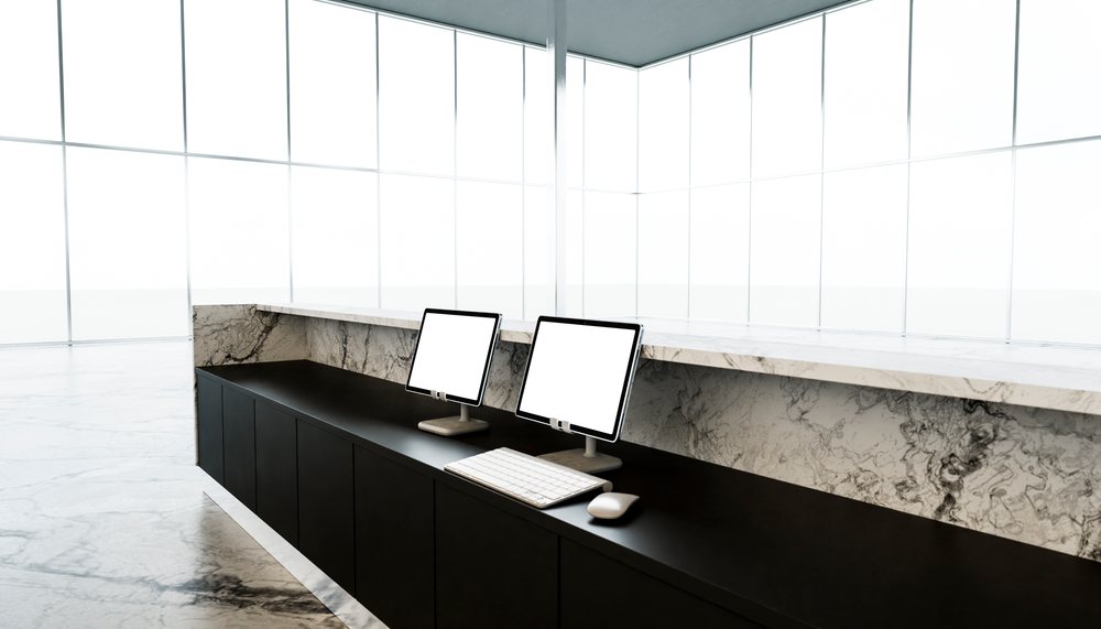 Reception desk with computers in modern office lobby.